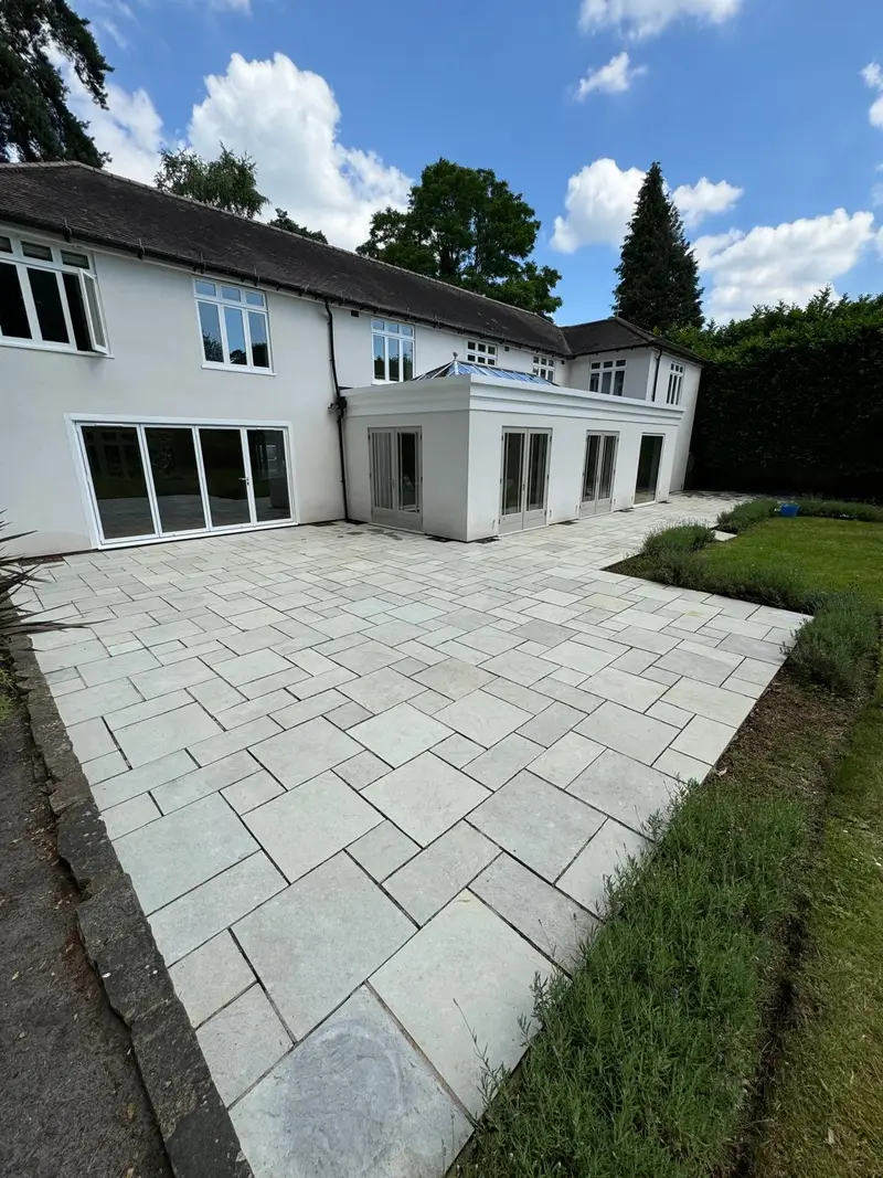 Clean grey stone patio behind a white house
