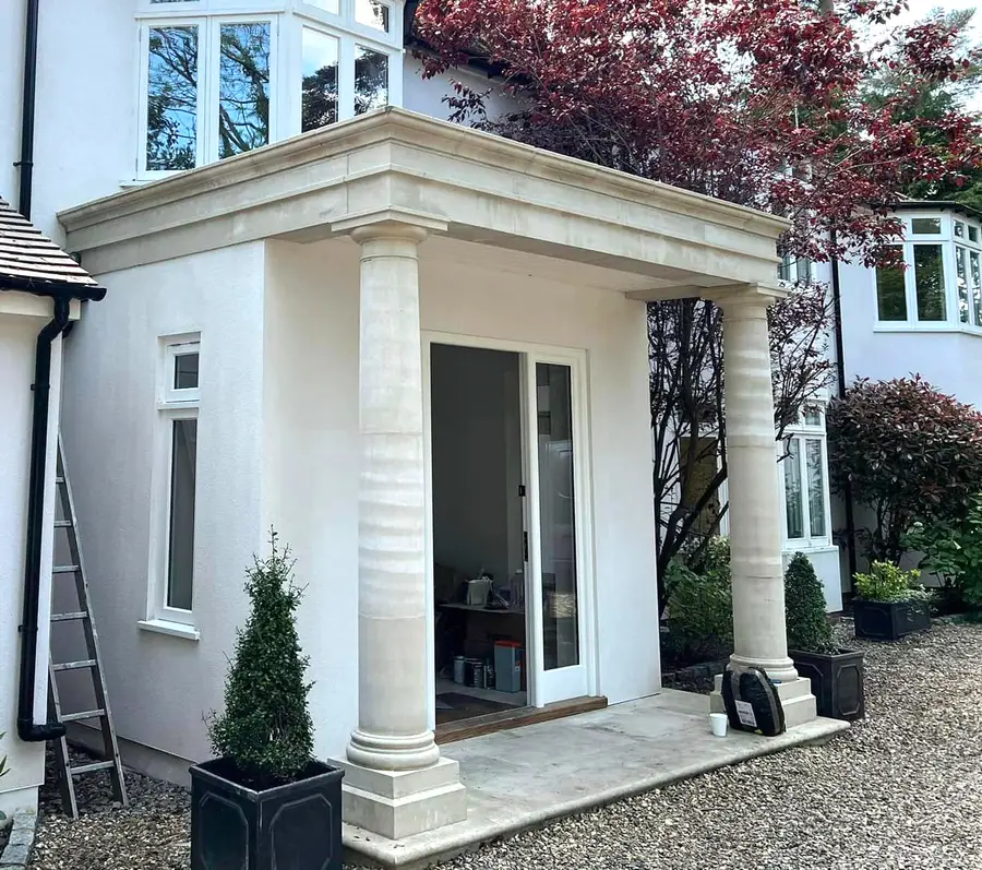 Bright white rendered porch with stone columns