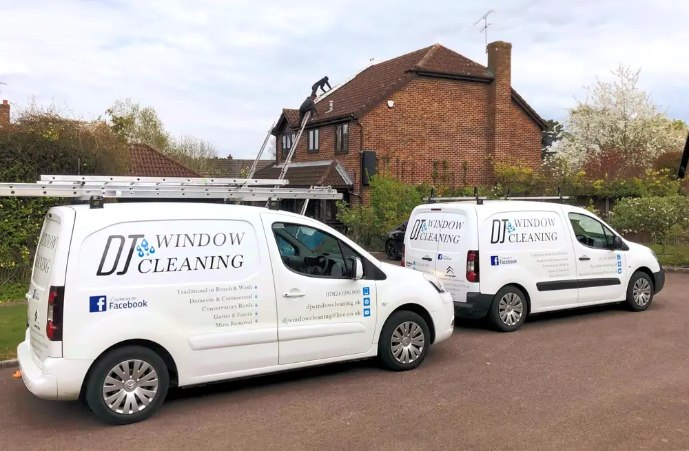 DJ Window Cleaning vans with ladders outside a house